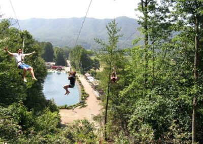 three kids on zipline toward lake